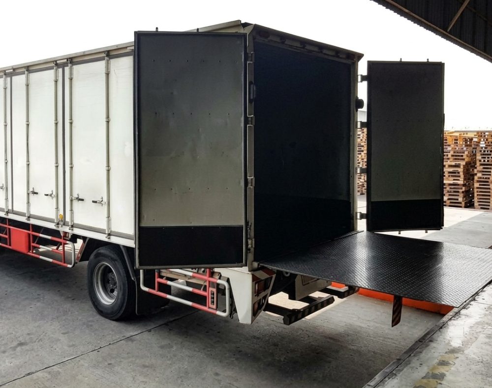 Delivery truck with open rear doors and loading platform.